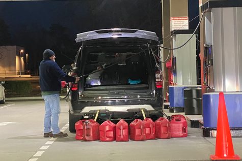 A man at Costco fills up multiple jerry cans in anticipation for rising gas  prices (SCCC Multimedia/Sara McGiff).
