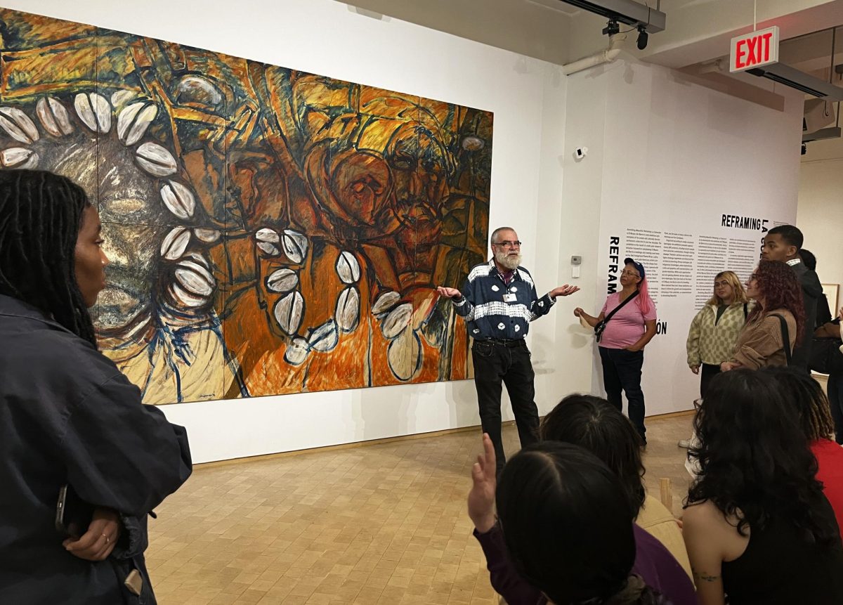 Paul Lambermont, a tour guide at El Museo del Barrio, sharing his thoughts behind the meaning of the piece “Madama of the Shells” by Diógenes Ballester to the group of Suffolk students on Oct. 6, 2023. (Elisha Feliz/Compass News)
