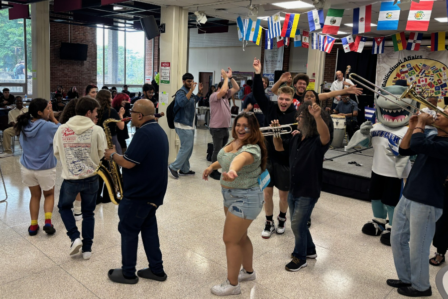 Students form a conga line while dancing to live music performed by the salsa band La Sonora 495.