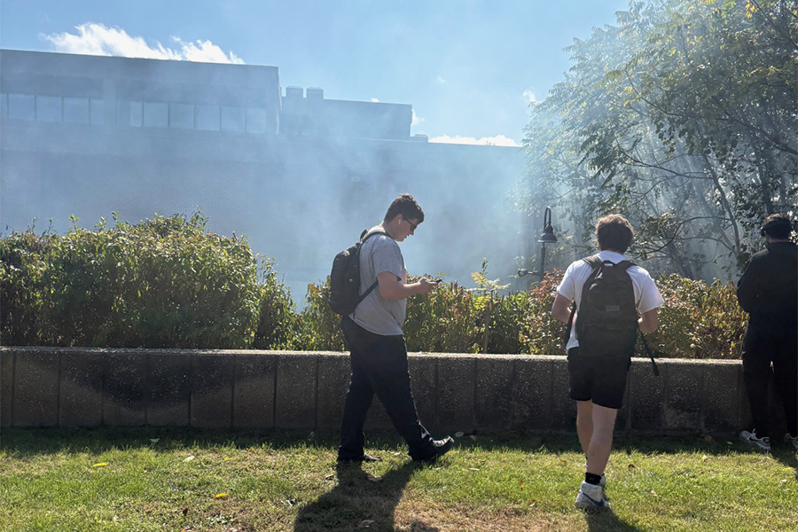 Students walk in the quad after smoke from a brush fire forced an evacuation of the Riverhead Building on Oct. 7, 2025