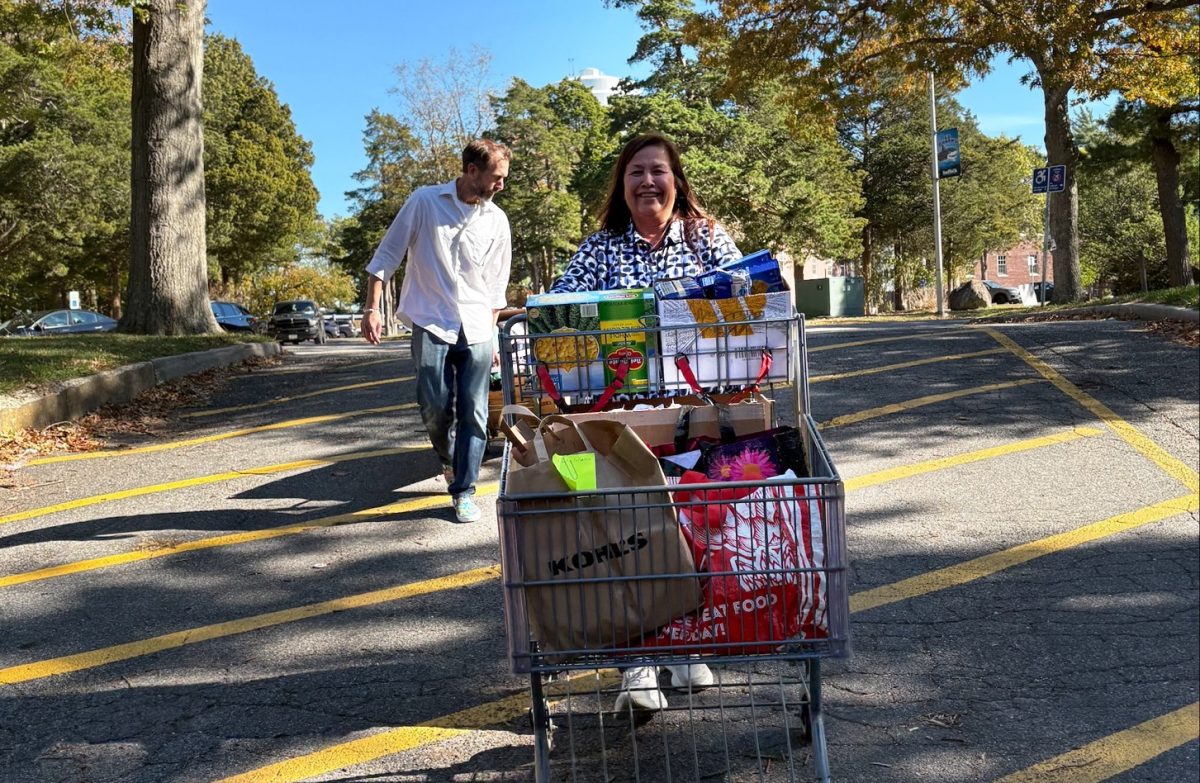 Professors Raymond DiSanza and Kimberly Ng-Southard deliver donations collected by the English department to the food pantry using shopping carts.